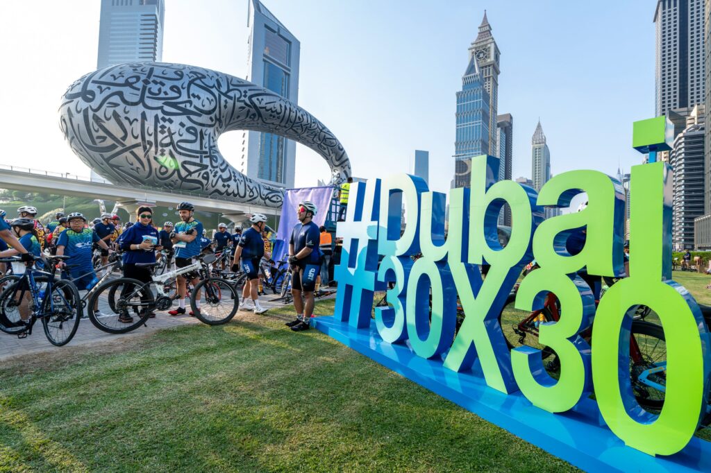 Riders at the Dubai 30x30 sign